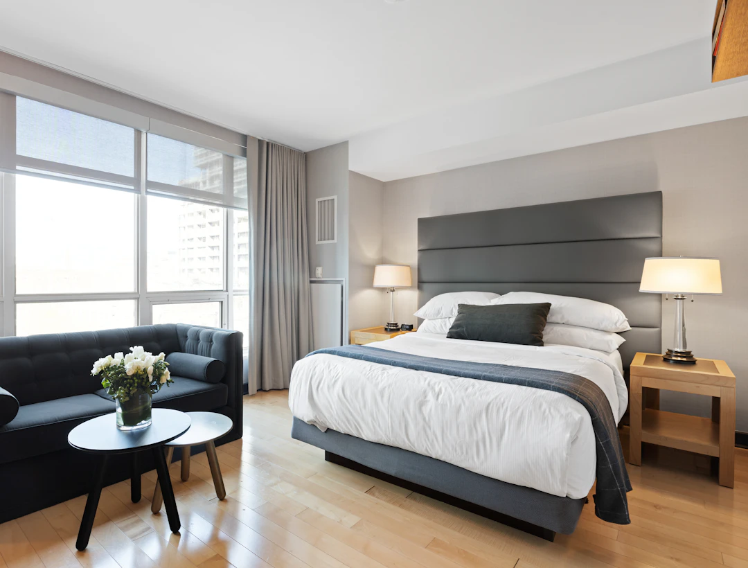 Bright hotel room with a bed and seating area