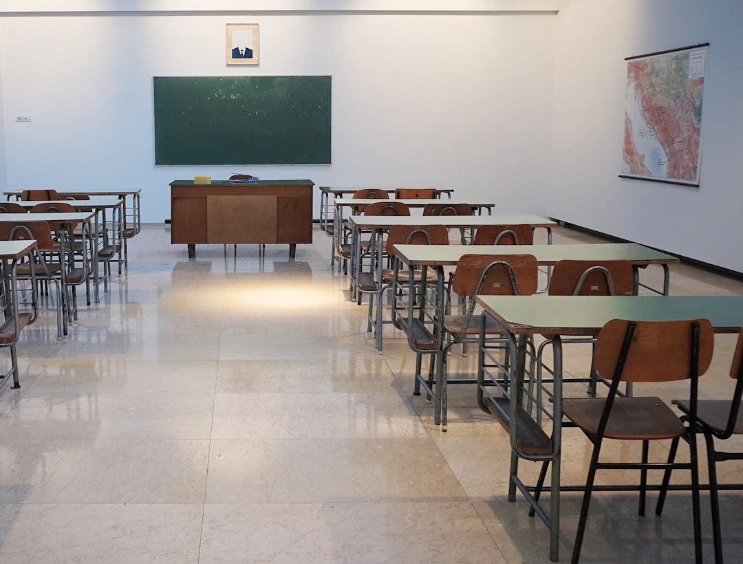 Empty classroom with rows of desks and a chalkboard